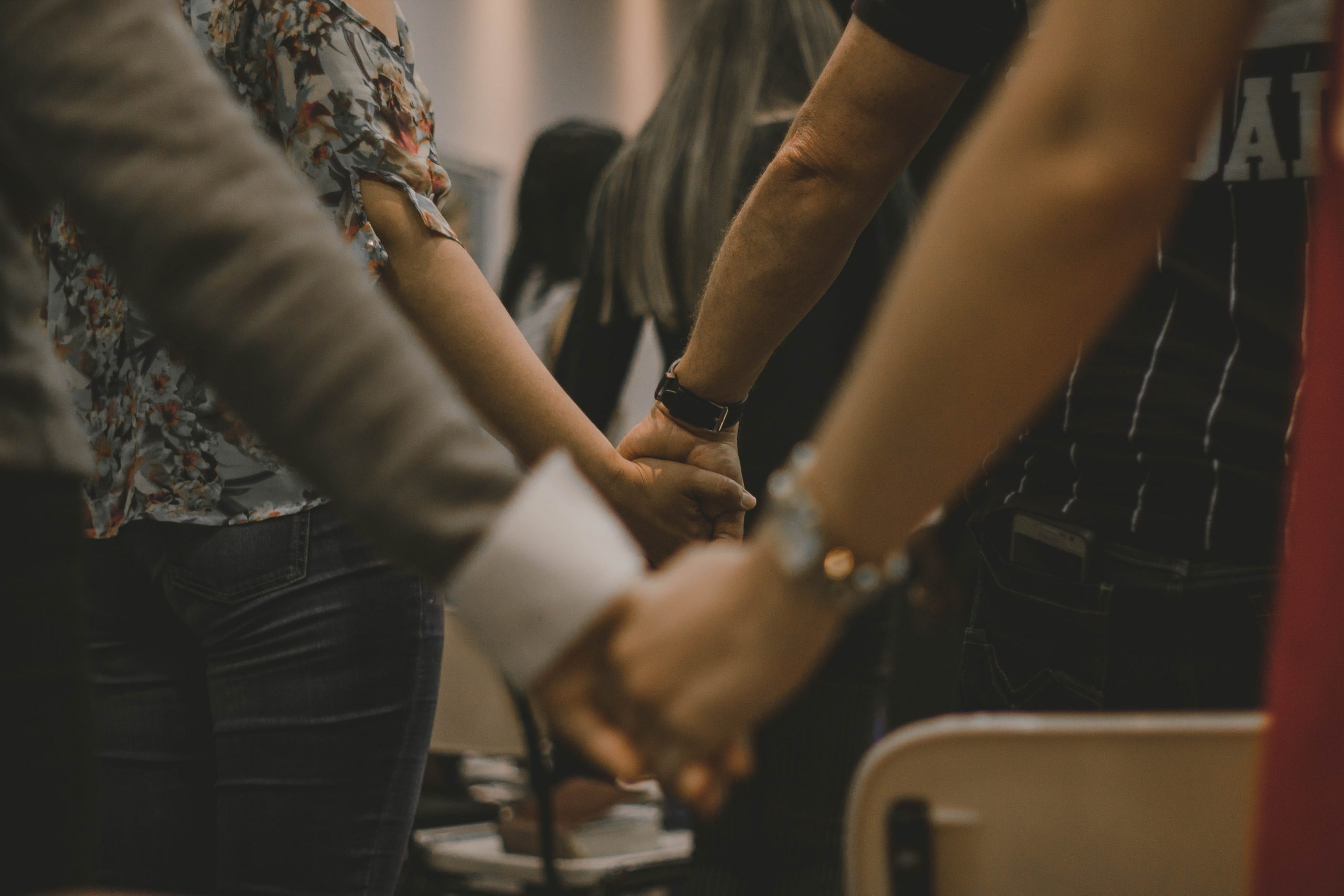 Mensen hand in hand in gebed
